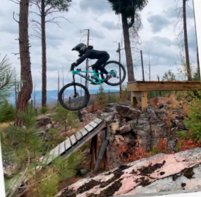 Vanessa Hair riding a mountain bike over a drop with a gap. Leader of our mountain bike clinic.