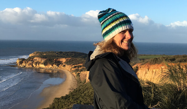 An image of Tori Hanson on a cliff above a beach