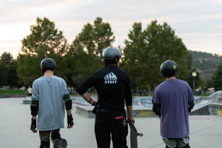 staff and youth learning at skate park