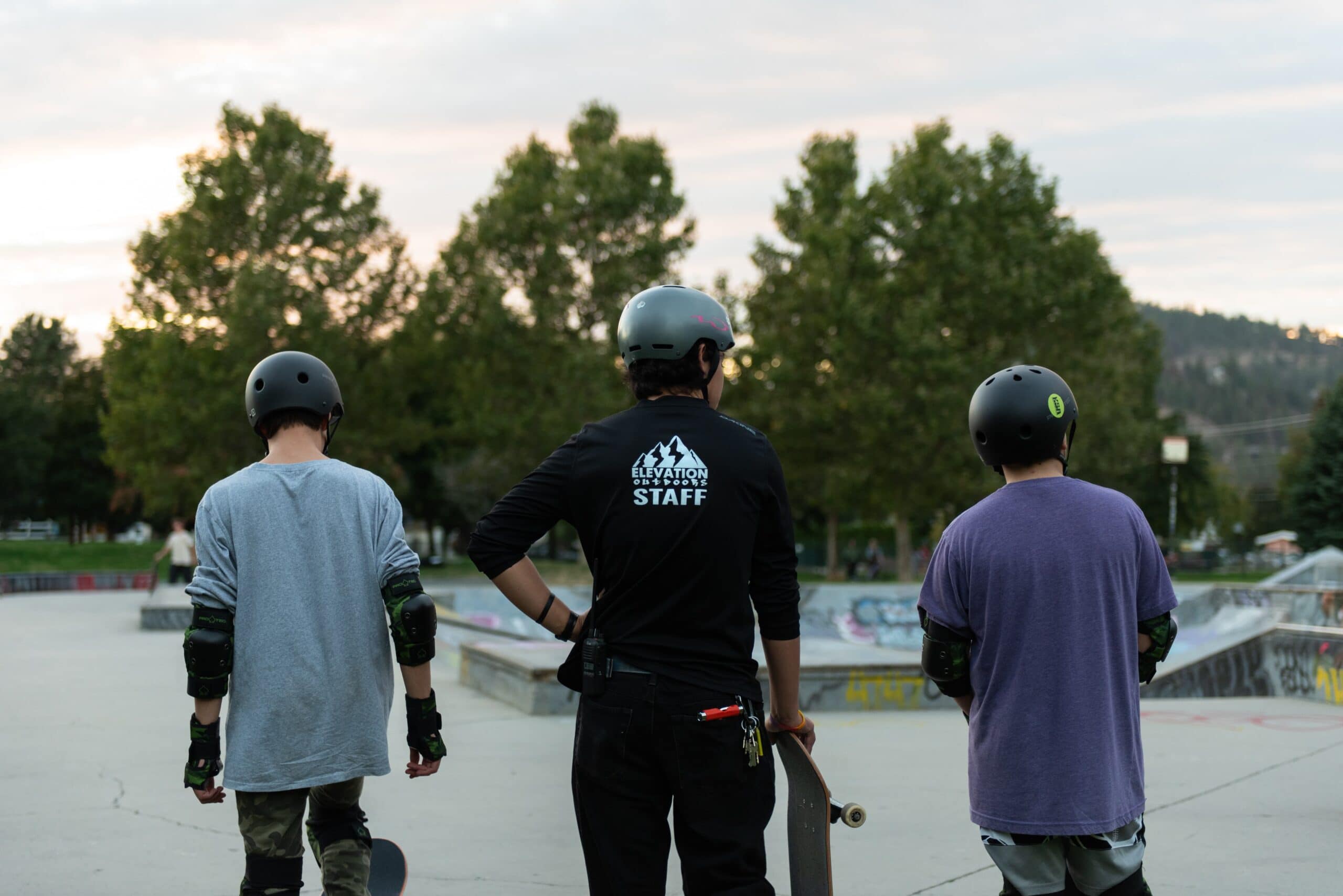 staff and youth learning at skate park